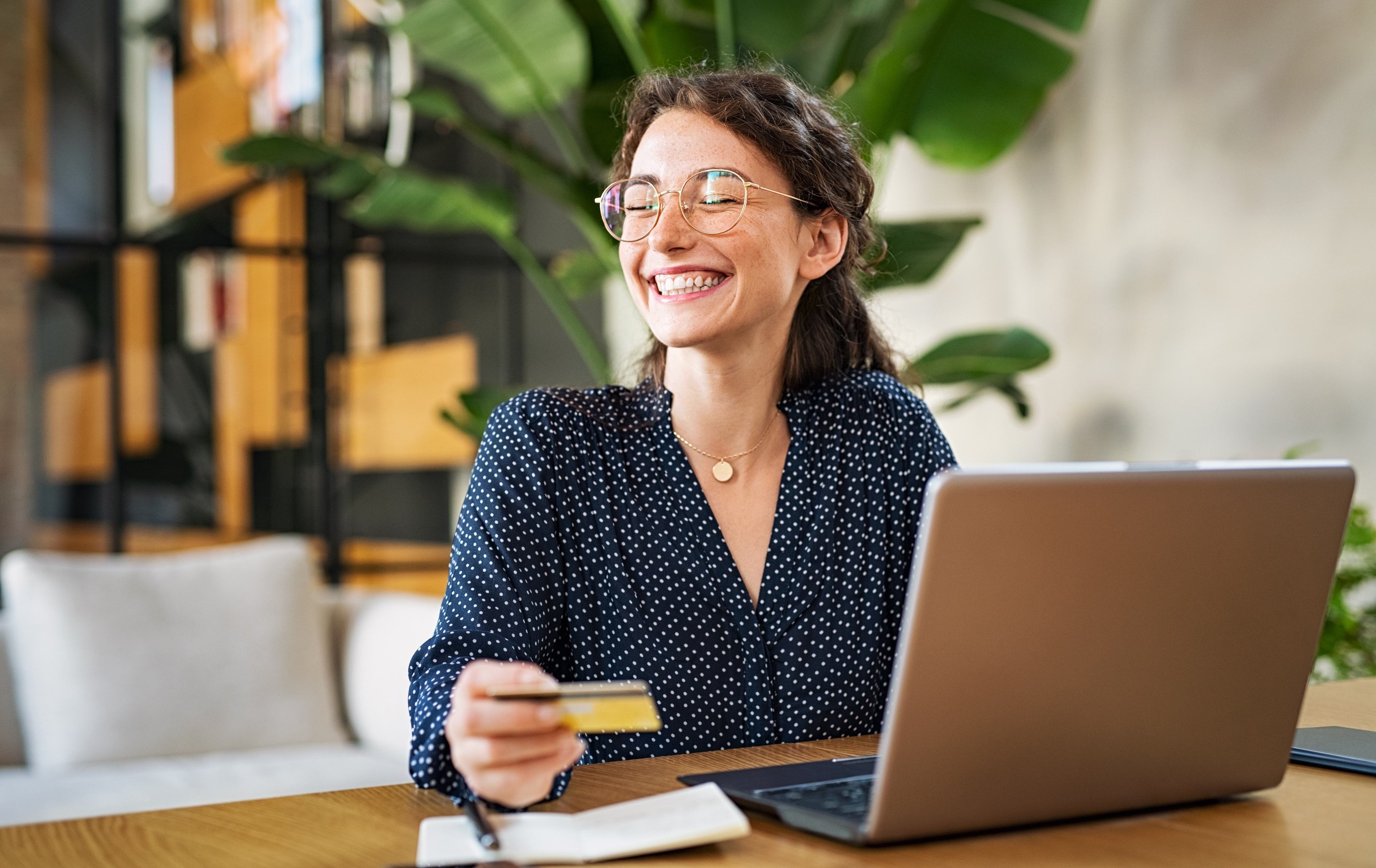 Professionista sorridente al portatile con una carta in mano